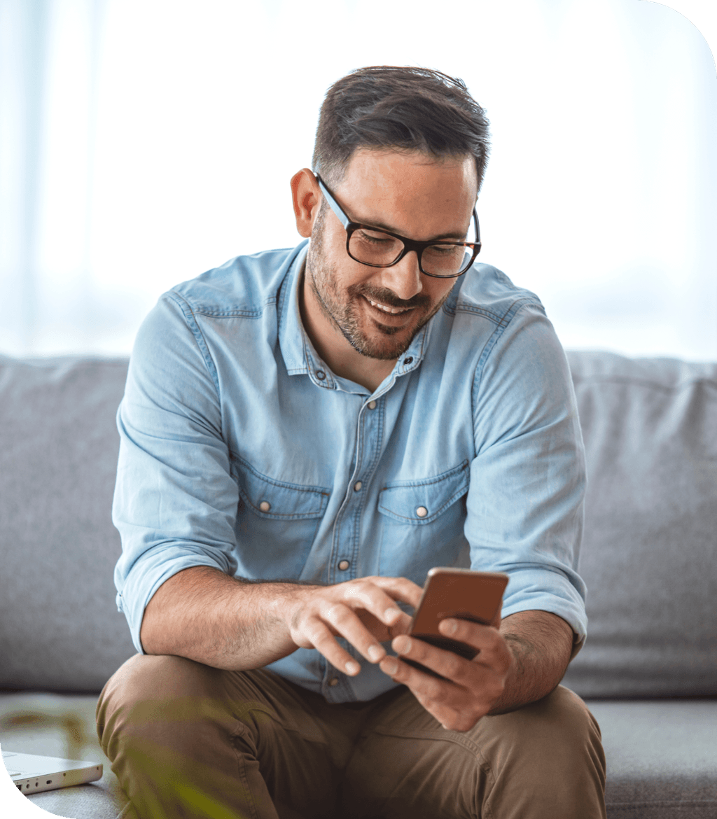 Mann mit Smartphone auf der Couch